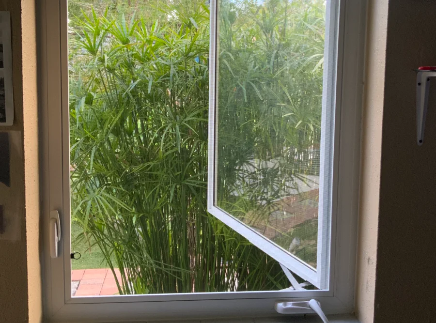 Impact casement window cranked open from the inside, showing the scissor arm and crank handle