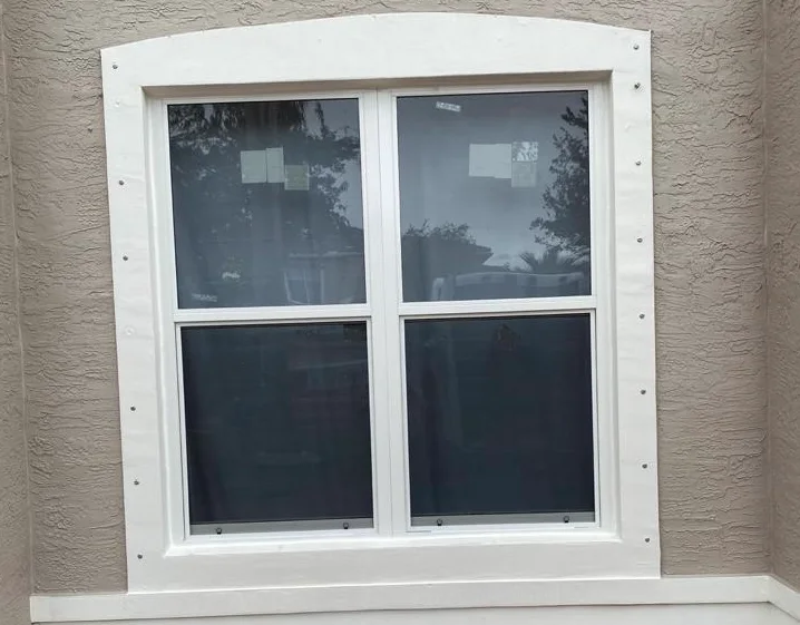 Twin white-framed impact double hung windows, each with a horizontal meeting rail, in a South Florida stucco wall